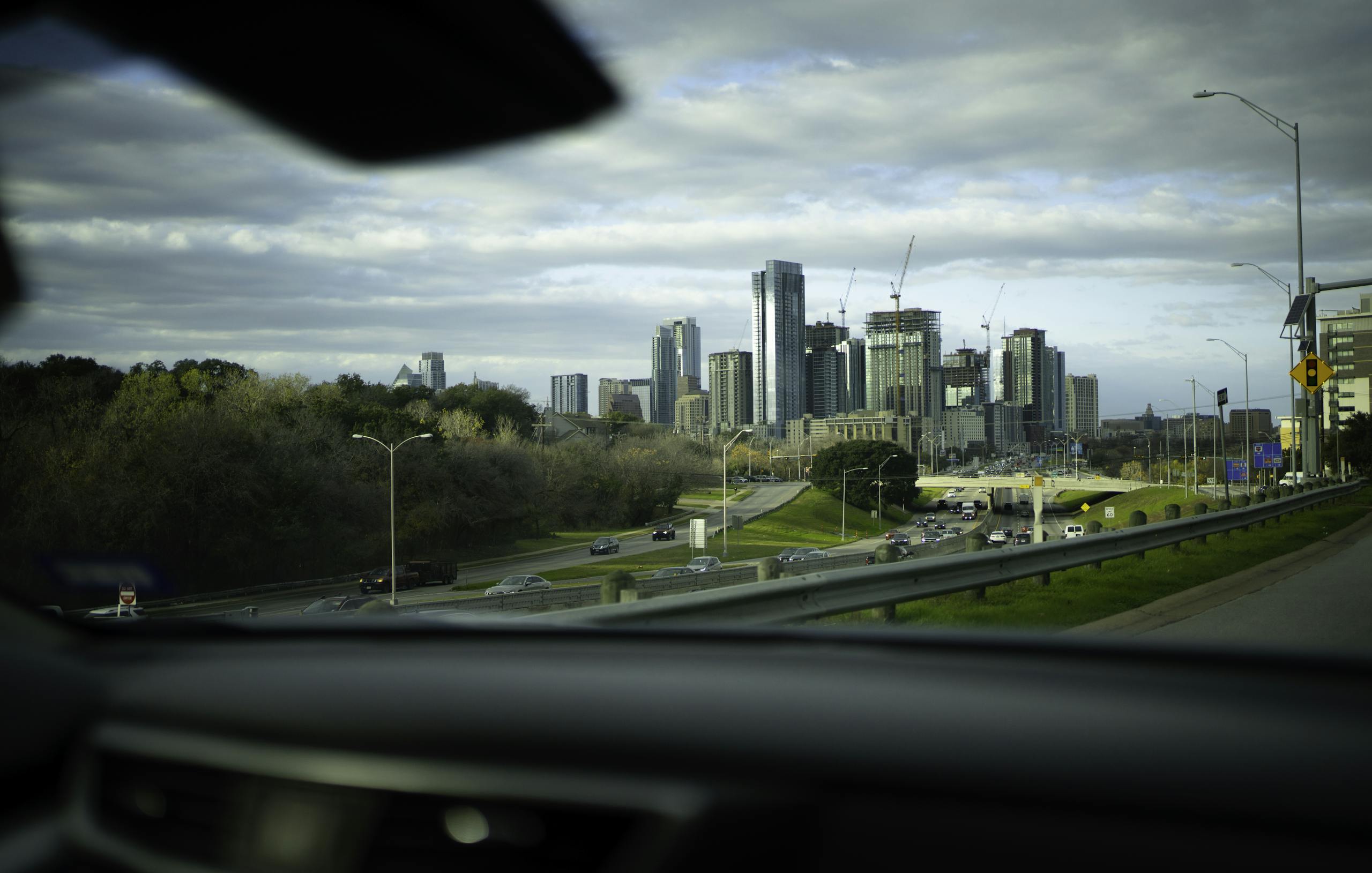 Dynamic view of Austin skyline from a car, capturing skyscrapers and urban life.